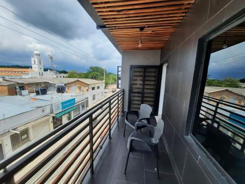a balcony with two chairs and a view of the city at Hotel Almalu in Aguachica