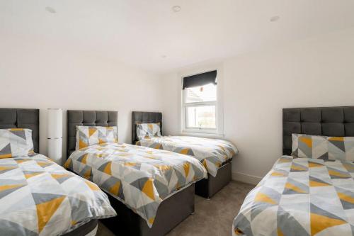 a bedroom with two beds and a window at Maybury Maison in Woking