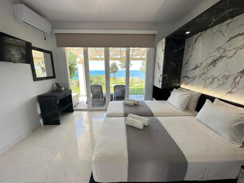 una camera con due letti e vista sull'oceano di Nikos Apartments Corfu ad Agios Stefanos