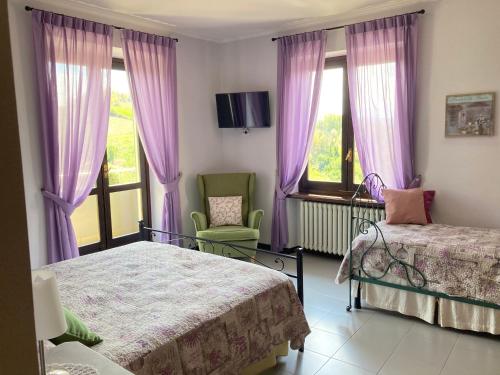 a bedroom with two beds and a window with purple curtains at IL SEGNAVENTO in Cassinasco