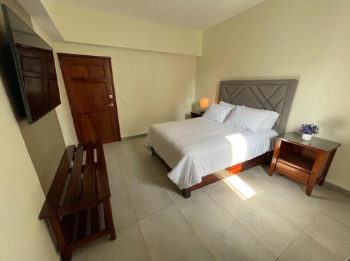 - une chambre avec un grand lit blanc et une table dans l'établissement HOTEL CASABLANCA, à Xilitla