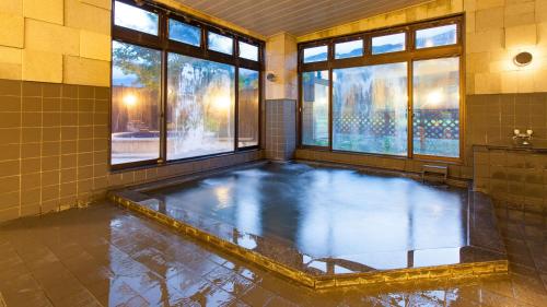 a swimming pool in a room with windows in a bathroom at Villa Schole Hakuba - Vacation STAY 19577v in Yotsuya