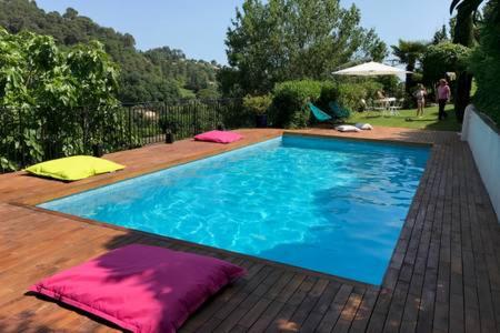 - une piscine avec des oreillers sur une terrasse en bois dans l'établissement SAINT PAUL EN JARDIN, à Saint-Paul-de-Vence