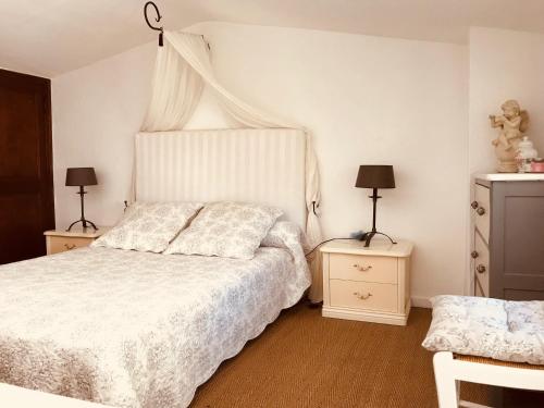 - une chambre avec un lit blanc et 2 tables de chevet dans l'établissement SAINT PAUL EN JARDIN, à Saint-Paul-de-Vence