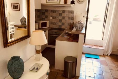 une cuisine avec un vase posé sur des toilettes dans l'établissement SAINT PAUL EN JARDIN, à Saint-Paul-de-Vence