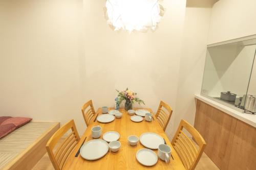 uma mesa de jantar com pratos brancos e cadeiras em Ｑｕｅｅｎｓ Ｐａｒｋ ＣＫ ＶＩＬＬＡＧＥ Ｎｉｓｅｋｏ Ｈｉｒａｆｕ Ｉ - Vacation STAY 14145 em Niseko