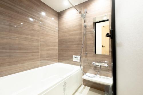 uma casa de banho com um chuveiro, uma banheira e um lavatório. em Ｑｕｅｅｎｓ Ｐａｒｋ ＣＫ ＶＩＬＬＡＧＥ Ｎｉｓｅｋｏ Ｈｉｒａｆｕ Ｉ - Vacation STAY 14145 em Niseko