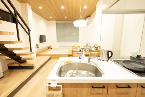 uma cozinha com um lavatório e uma escada em Ｑｕｅｅｎｓ Ｐａｒｋ ＣＫ ＶＩＬＬＡＧＥ Ｎｉｓｅｋｏ Ｈｉｒａｆｕ Ｉ - Vacation STAY 14145 em Niseko