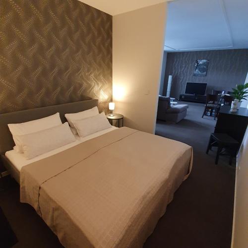 a bedroom with a large bed and a living room at Ferienapartment Lilo in Eisenhüttenstadt