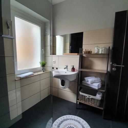 a bathroom with a sink and a mirror at Ferienapartment Lilo in Eisenhüttenstadt