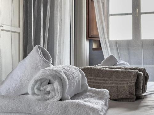 een stapel handdoeken bovenop een bed bij Borgo Pian di Sala in San Gimignano