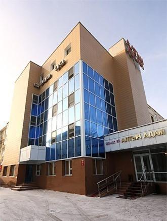 a large building with blue glass windows on it at Altyn-Adam Hotel in Astana
