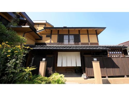 a house with white doors and a fence at Saikatei Jidaiya - Vacation STAY 96429v in Kaminoyama