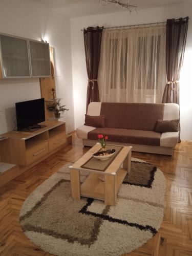 a living room with a couch and a coffee table at DORA Apartman in Palić
