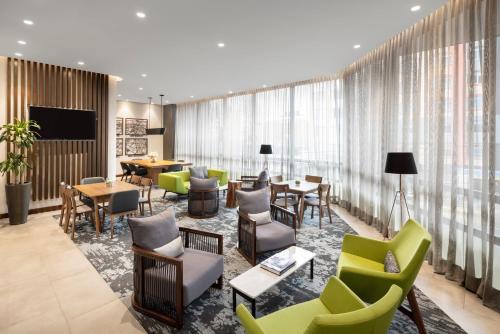 a hotel lobby with tables and chairs and windows at Hyatt Place Bogota Convention Center in Bogotá