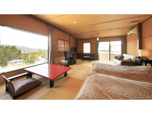 a hotel room with a bed and a table and a couch at Saikatei Jidaiya - Vacation STAY 96444v in Kaminoyama