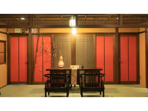 a room with red doors and a table and chairs at Saikatei Jidaiya - Vacation STAY 96452v in Kaminoyama