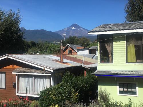 a group of houses with a mountain in the background at Ruka Pucón Hostel in Pucón