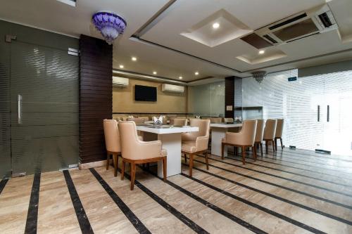 a dining room with a table and chairs at Capital O Corporate Inn in New Delhi