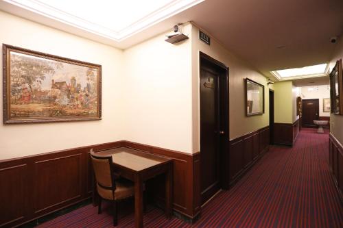 un couloir avec une table et un tableau sur le mur dans l'établissement Hamilton Hotel, à New Delhi