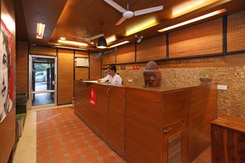 a woman sitting at a counter in a kitchen at Collection O Hamilton Hotel in New Delhi