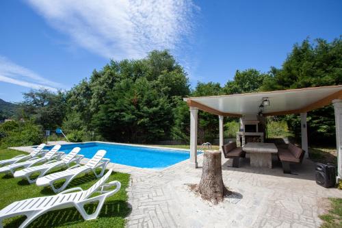 un grupo de tumbonas blancas junto a una piscina en Espectacular Casa con Piscina en Allariz, en Allariz