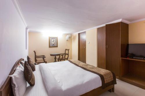 1 dormitorio con 1 cama, TV y mesa en OYO Hotel Landmark Inn en Nueva Delhi