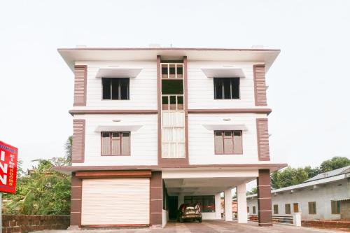 a white house with a garage in front of it at SPOT ON Rohini Inn Kadampuzha in Kottakkal