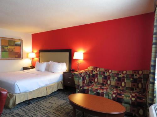 a hotel room with a bed and a chair at American Inn & Suites in Ferndale