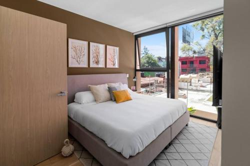 a bedroom with a large bed and a large window at H4U l Amplio apartamento de lujo 2 Hab + Terraza privada in Mexico City