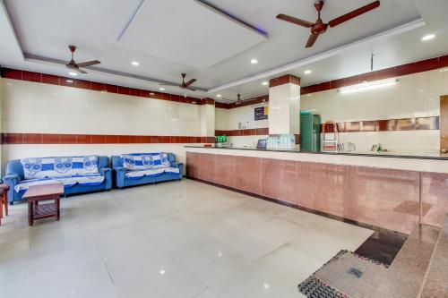 a waiting room with blue chairs and a bar at OYO Srinivasa Residency in Tirupati