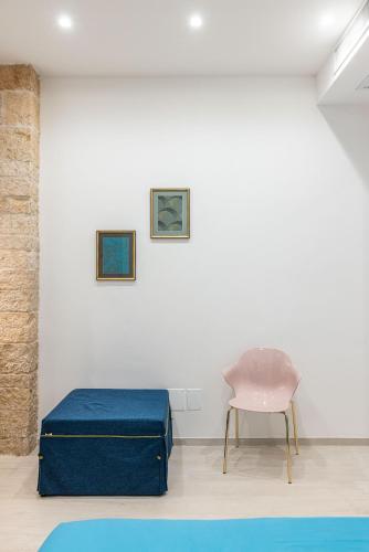 a room with a blue ottoman and a chair at Vivarum b&b in Bitonto