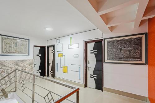 una escalera en una casa con obras de arte en las paredes en OYO Home Exotic Stay, en Bhubaneshwar