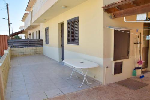 a patio of a house with a white table at Pervolina countryside by the sea in Pervolia