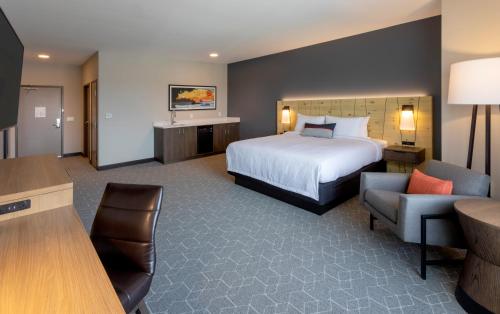 a hotel room with a bed and a chair at Running Aces Hotel & Casino, Trademark Collection by Wyndham in Forest Lake