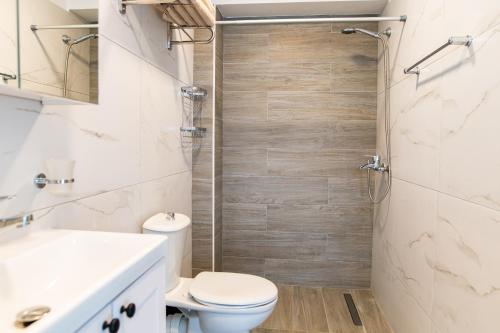 een badkamer met een douche, een toilet en een wastafel bij Zoes Apartment Kos Town in Kos-stad