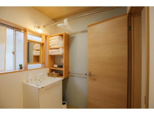 a bathroom with a sink and a wooden door at KONOHANA NO IORI - Vacation STAY 15340v in Mimasaka