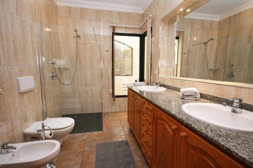 a bathroom with two sinks and a shower and a toilet at Casa Ronda in Charco del Palo