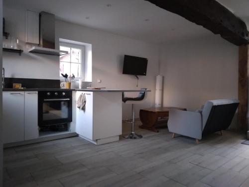 a kitchen with a desk and a table and a chair at Sandrine in La Ferté-Saint-Aubin