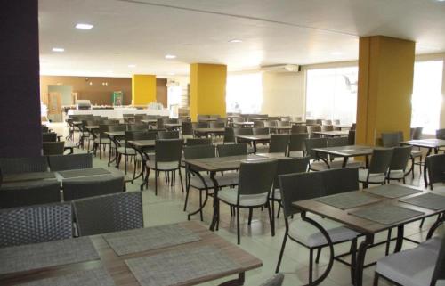 un comedor con mesas y sillas en un edificio en Veredas do Rio Quente Hotel Service en Rio Quente