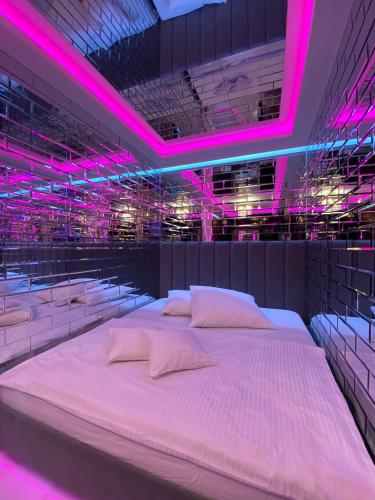 Cama grande en habitación con luces rosas en Apartament "Love Paradise" Centrum z dużą wanną dla Dwojga, en Gniezno