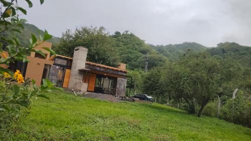 una casa en una colina con un coche aparcado delante en Naturaleza y Paz en San Salvador de Jujuy