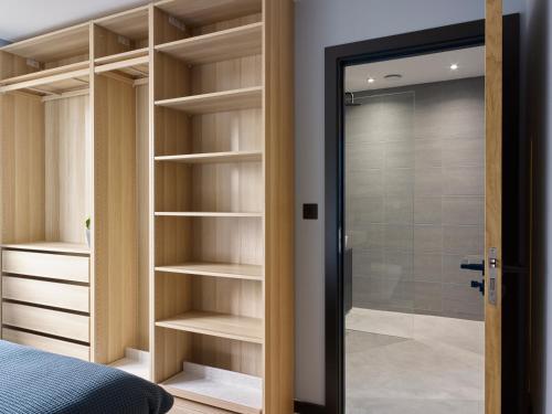a bedroom with a walkin closet with a glass door at Grand Designs Chess Valley Project - Rickmansworth in Rickmansworth