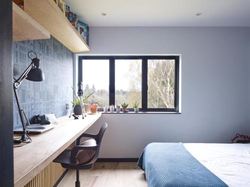 a bedroom with a desk and a bed and a window at Chess Valley modern home stay in Rickmansworth