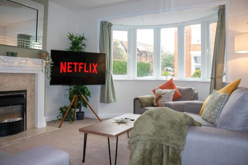 uma sala de estar com uma televisão com as palavras netflix em Causey Lodge superb comfy home in Exeter by StayStay em Exeter