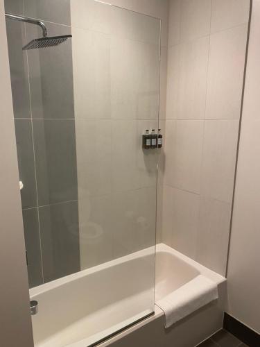 a shower with a glass door in a bathroom at Running Aces Hotel & Casino, Trademark Collection by Wyndham in Forest Lake