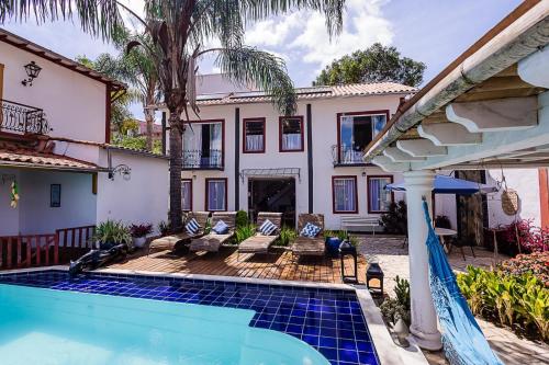 a house with a swimming pool in front of a house at Chalés Pôr do Sol in Tiradentes