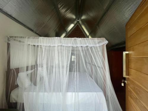 a bed with a white canopy in a room at Steps Garden Resort in Negombo