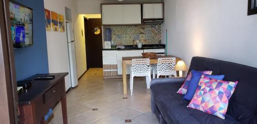 a living room with a couch and a table and a kitchen at Pousada Pedra da Gaivota in Bombinhas