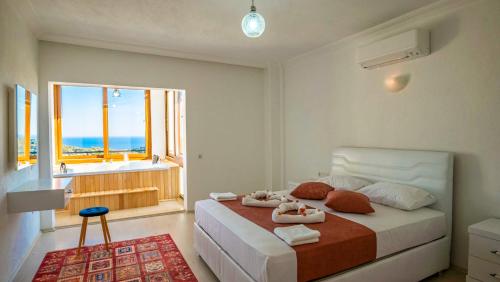a bedroom with a bed with a view of the ocean at VİLLA TANYERİ in Kas